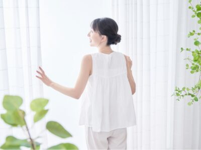 カーテンを開ける女性のイメージ